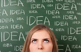 woman standing in front of blackboard with IDEA written on it multiple times